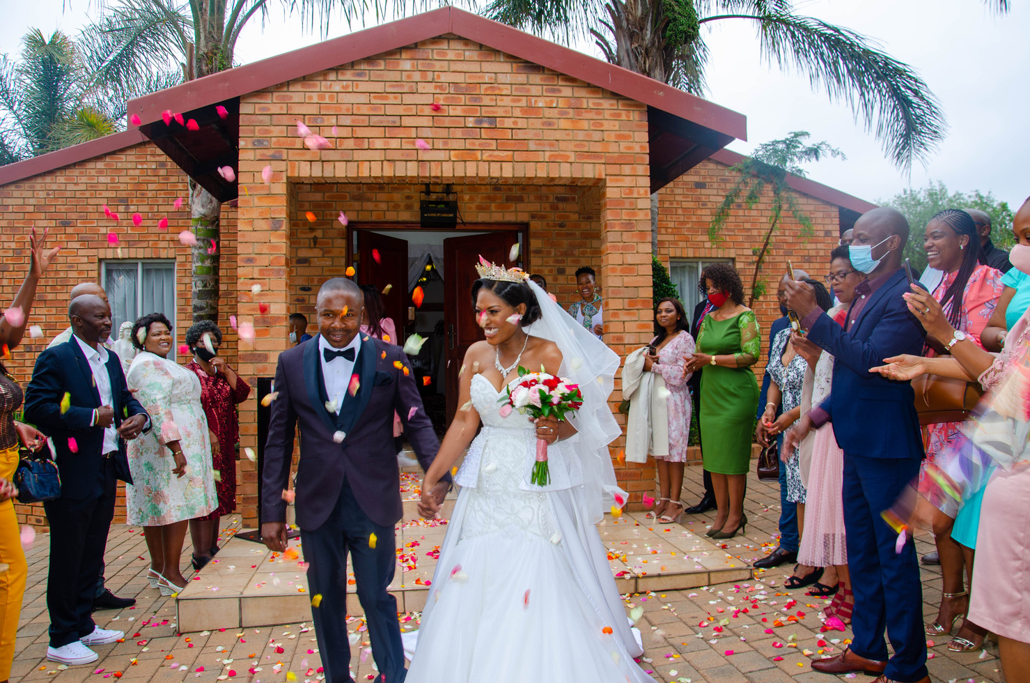Happy black newlywed couple at wedding among guests